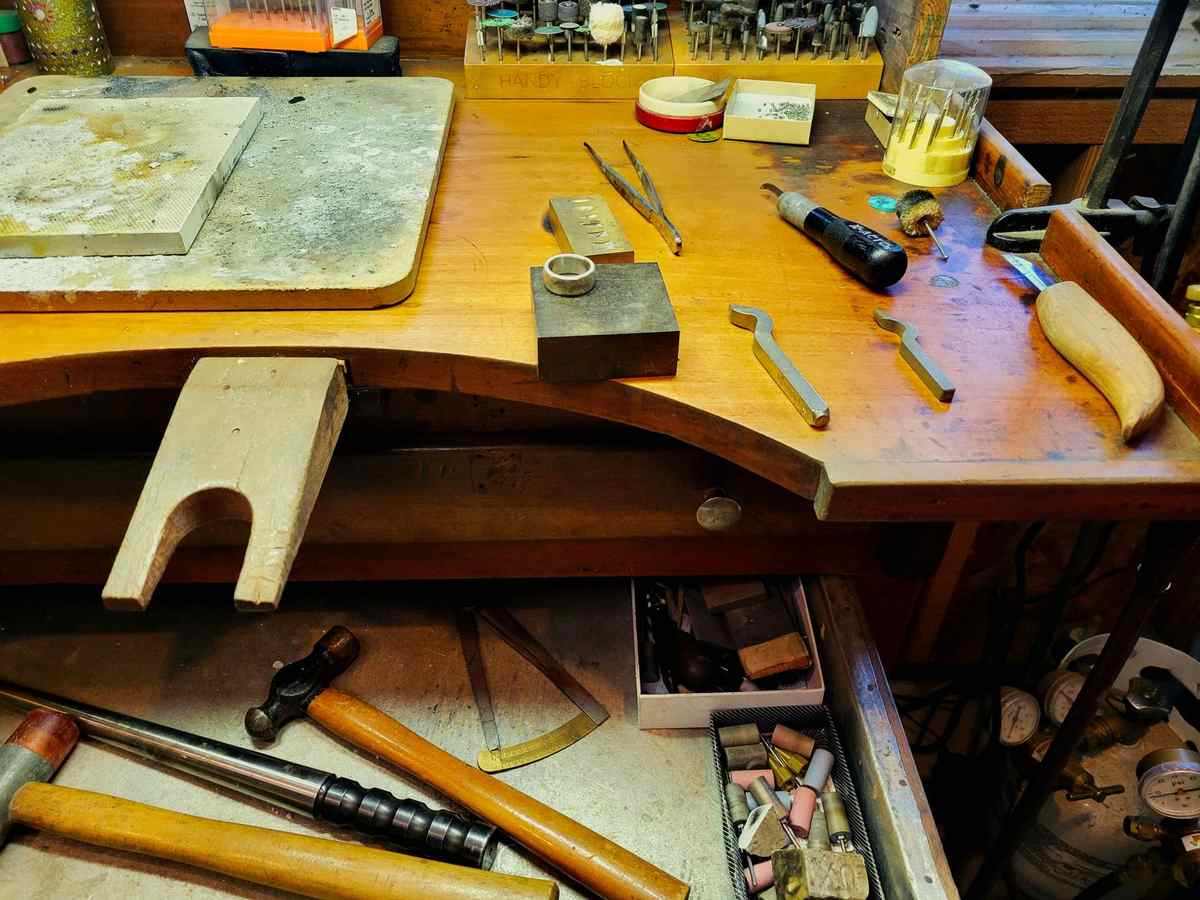 Établi d'ébéniste avec outils, bois travaillé et pièces de meuble en cours de restauration