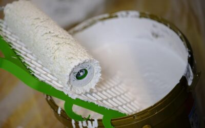 Rouleau de peinture immergé dans un seau de peinture blanche