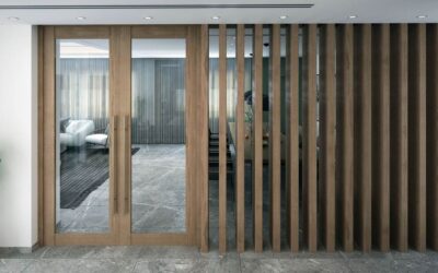 Vue d'un salon moderne derrière des portes vitrées et une cloison en bois