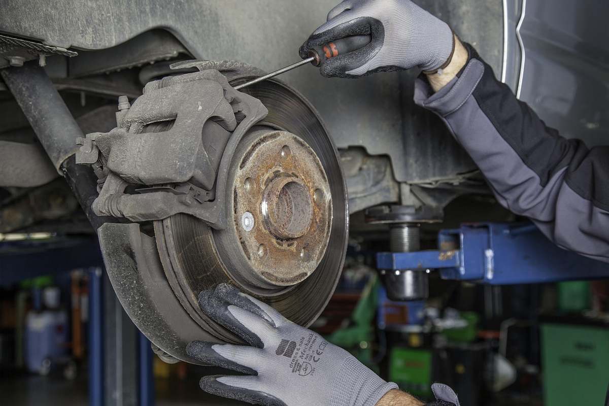 Un technicien retire une vis du disque de frein d'un véhicule