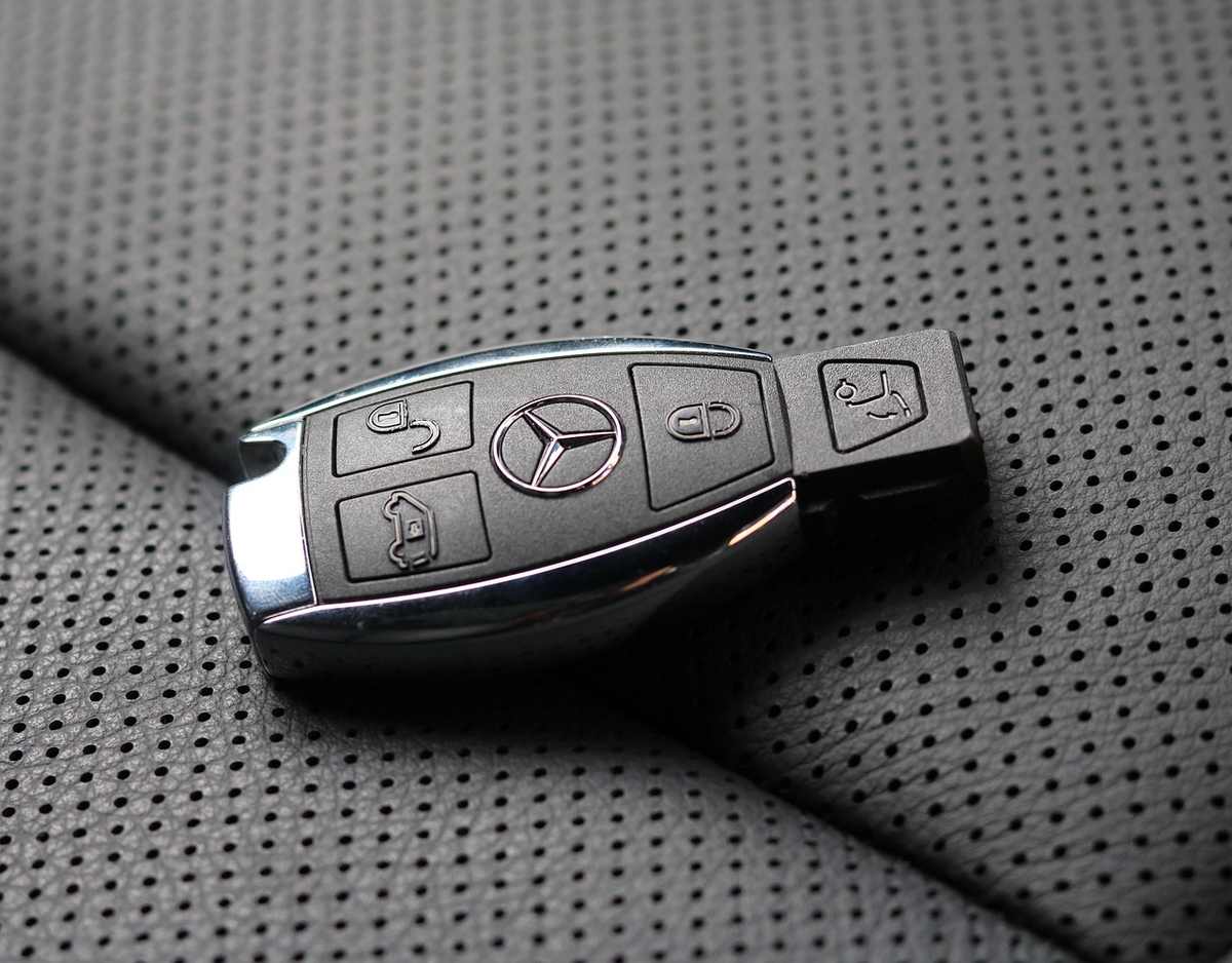 Clé de voiture Mercedes posée sur un siège en tissu perforé