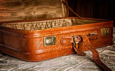 Un vieux suitcase en cuir ouvert, avec languette et cliquetis, sur tissu