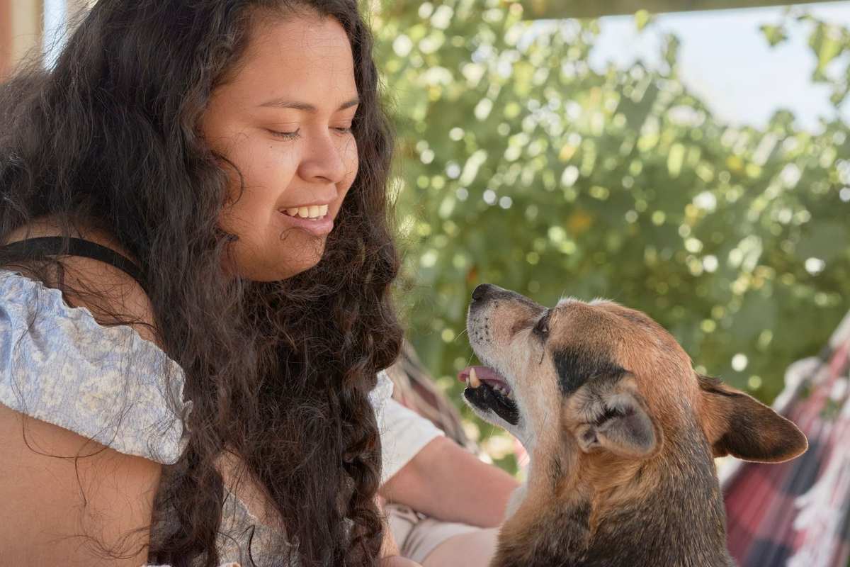 Femme et chien en interaction dans un cadre extérieur lumineux