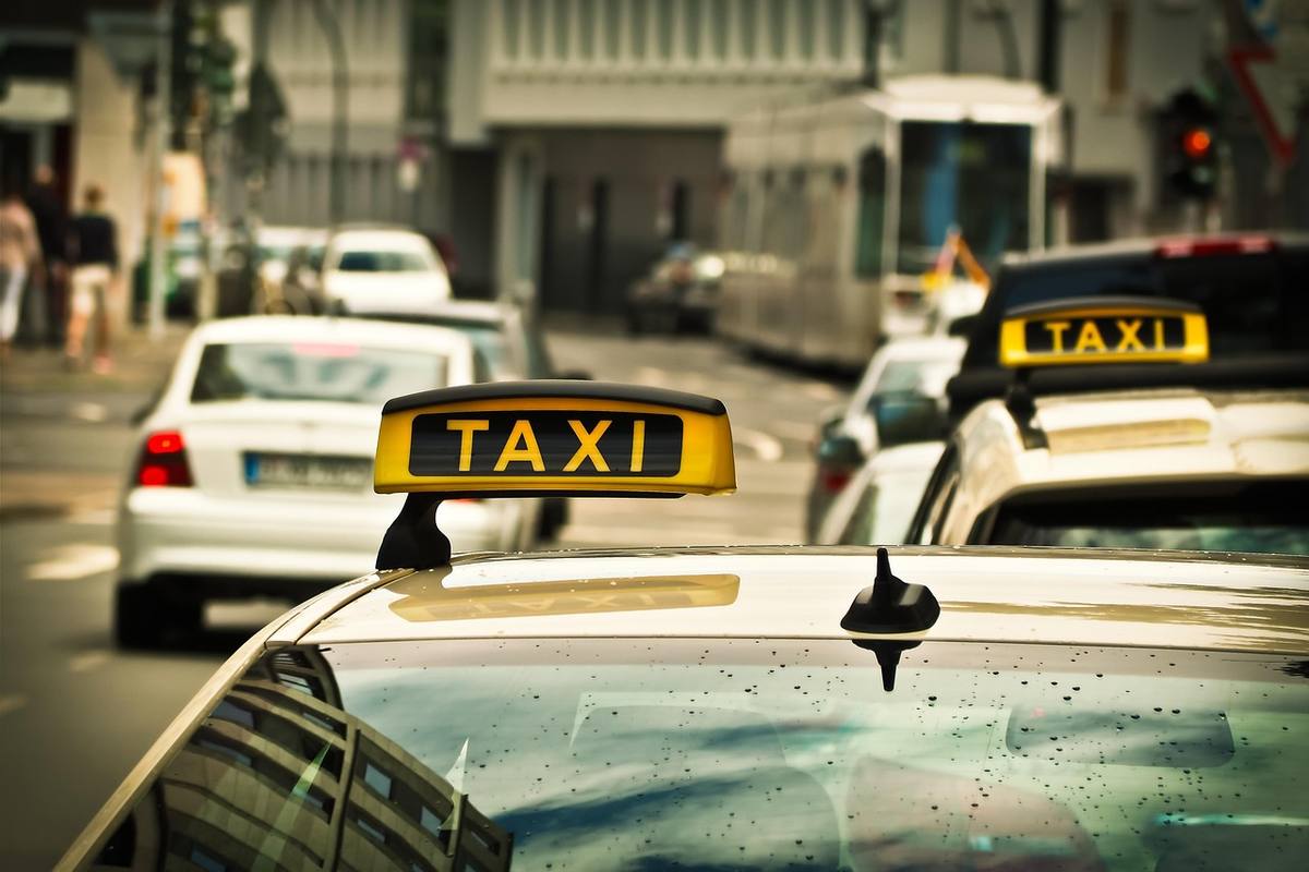 Des taxis jaunes avec enseignes 'TAXI' sur une rue bondée